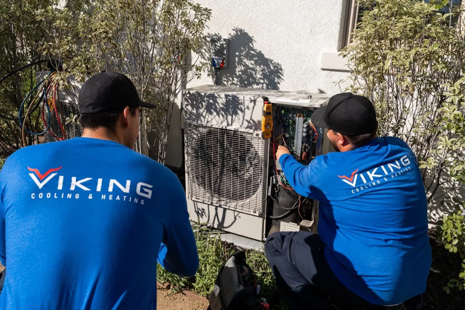 Two Viking technicians servicing an air-conditioning unit