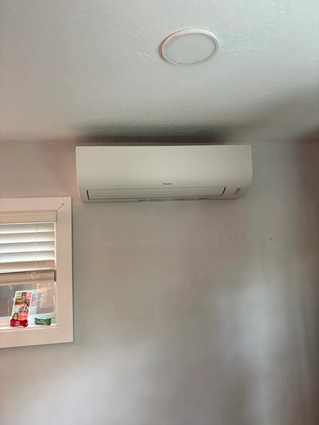 A ductless mini-split head mounted on a bedroom wall
