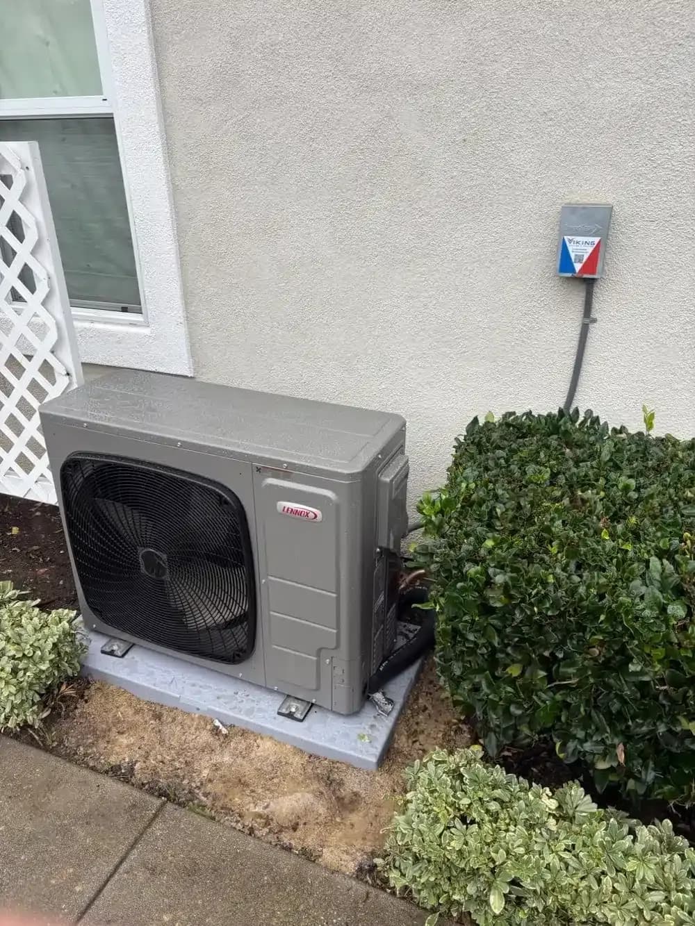 A Viking-installed heat pump condenser beside a home