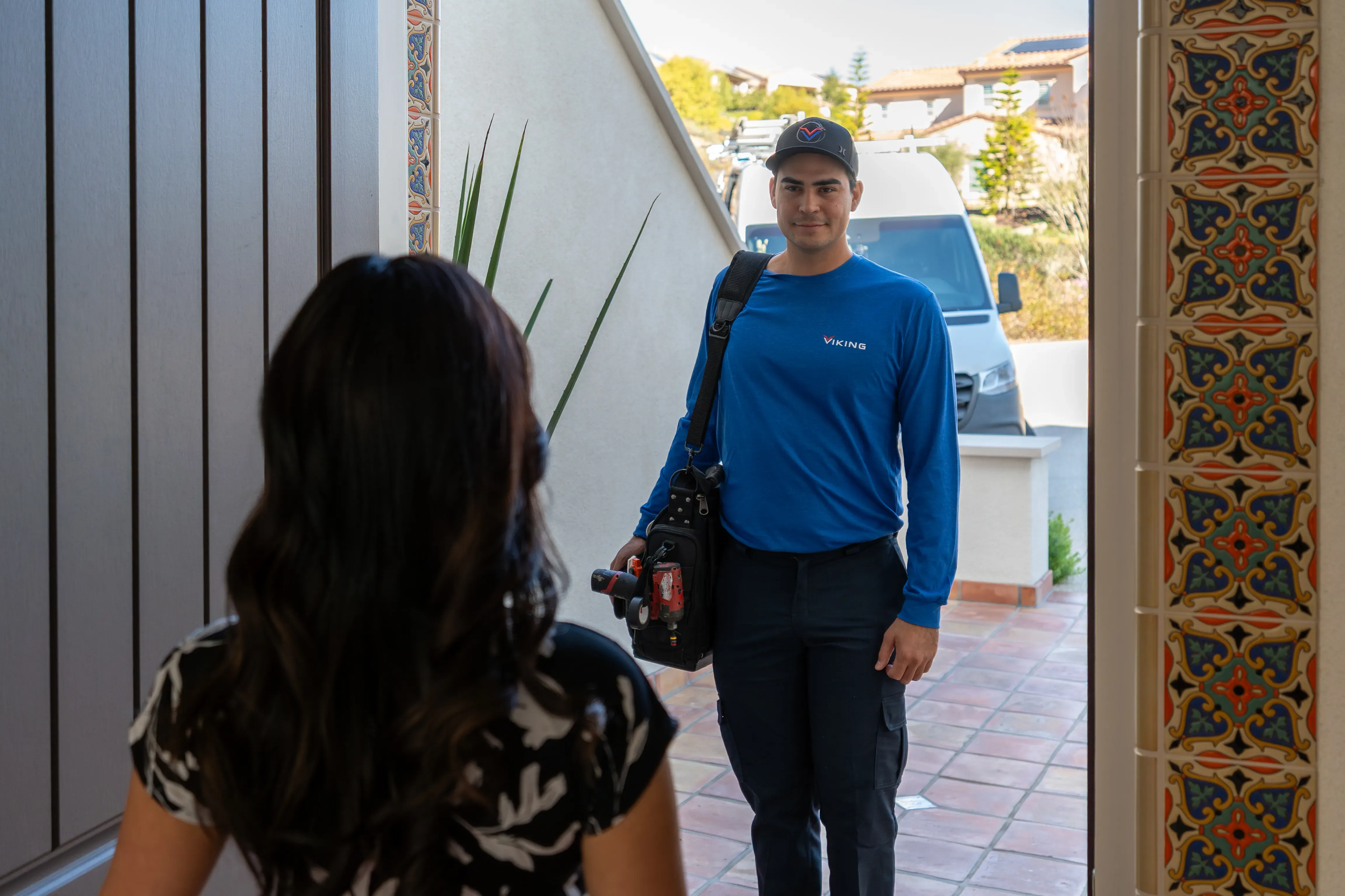A Viking technician walking up to a customer’s front door