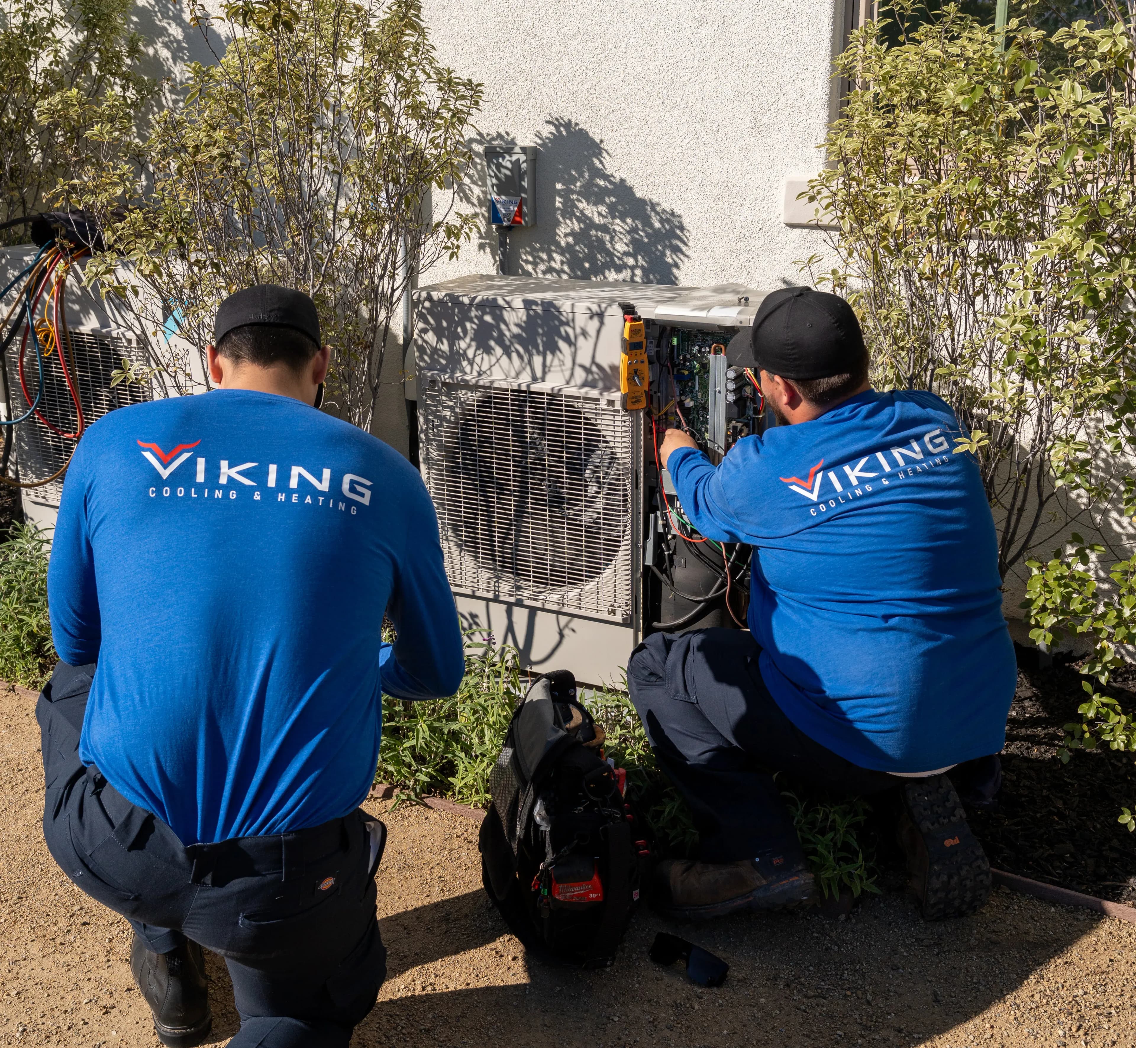 A Viking technician cleaning the coil on an outdoor AC condenser