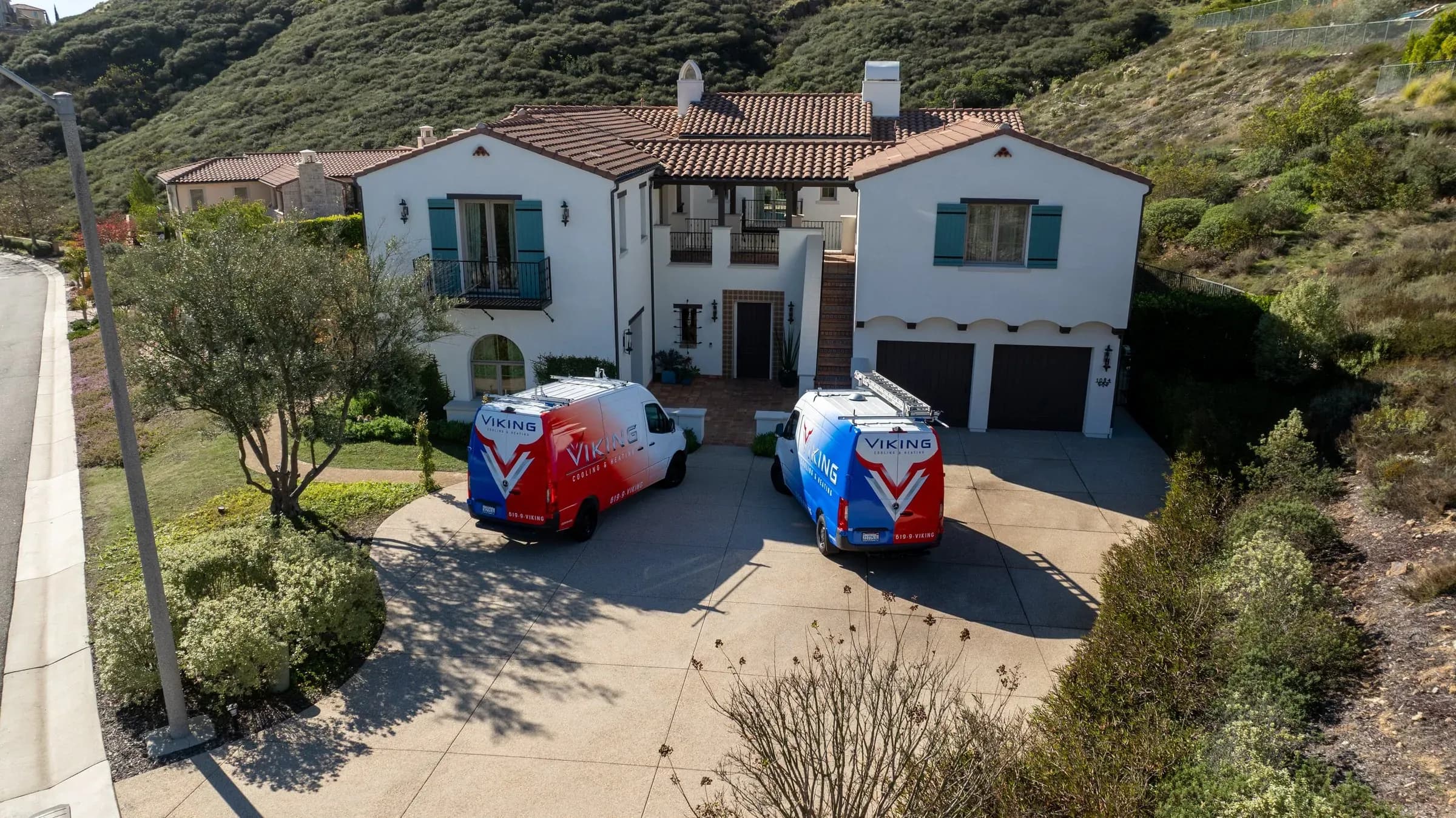Two Viking service vans parked in the driveway of a San Diego home
